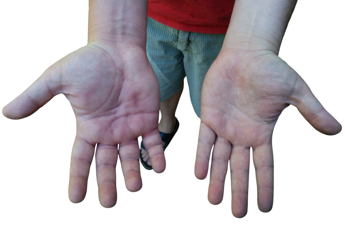 Close-up of a man’s large wrists and hands, representing the need for comfortable hair ties that fit bigger wrists.