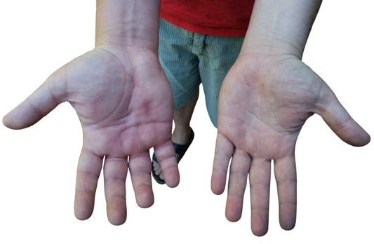 Close-up of a man’s large wrists and hands, representing the need for comfortable hair ties that fit bigger wrists.